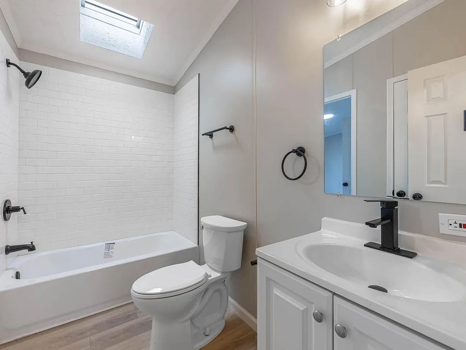 After: Carpet on the bathroom floor and old fixtures. New tile, vanity and tub.